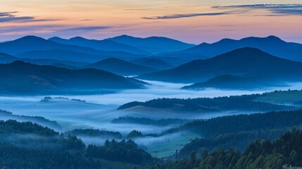 Misty sunrise over rolling blue mountains and valleys.