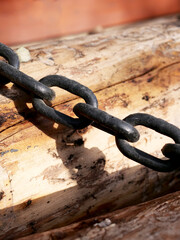 close-up black rusty chain on wood
