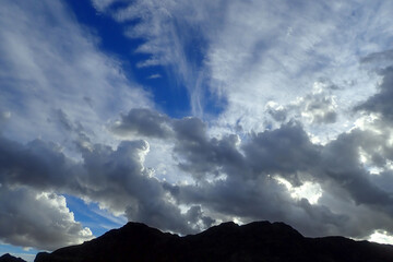 Colorful cloudscape over mountain silhouette