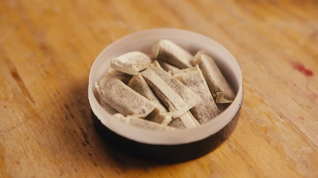 Snus nicotine tobacco close up, pack of tobacco for gum. unhealthy addiction.
