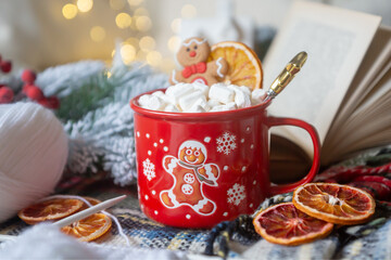 New Year 2025, tea with orange, coffee with marshmallows, books and fir branches, New Year's toys and a ball on the table.