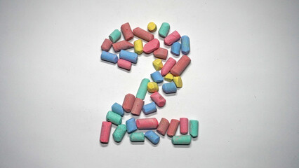 Colorful Chalk Pieces Forming the Number Two on White Background
