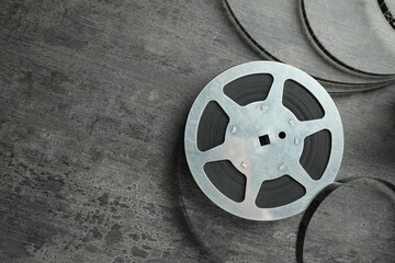 Film reel on grey textured table, top view. Space for text