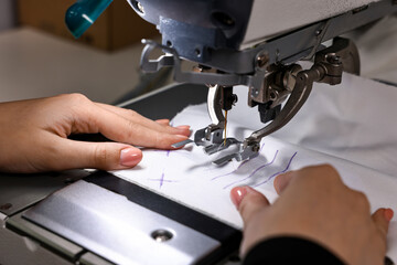 Woman working with sewing machine in professional workshop, closeup