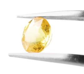 Tweezers with shiny yellow gemstone isolated on white