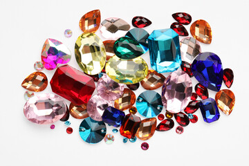 Different shiny gemstones on white background, top view