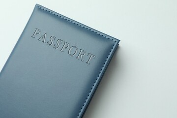 Passport in dark blue cover on light background, top view