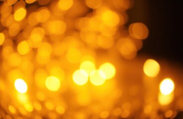 Obraz premium Blurred golden lights create festive background. Bokeh effect shows sparkles of gold. Abstract design. No people. Perfect for holiday or party decorations or luxury product images.
