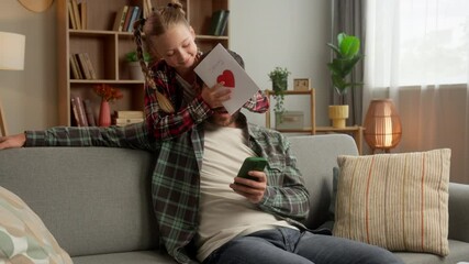 Caucasian child daughter girl surprise man dad male at home guy father smile receive gift handmade holiday card for Father's Day family carefree little kid schoolgirl congratulation parent celebration