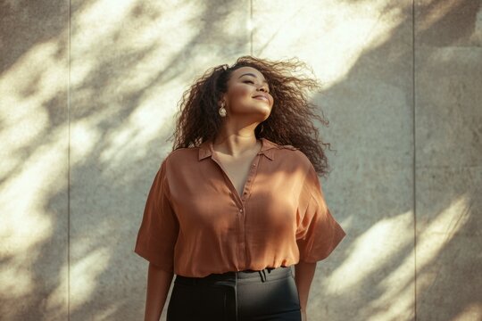 Plus size African American confident smile businesswoman with curly braun hair in city in summer day. Overweight female in casual clothes. photo