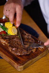 a man cuts a juicy steak with a knife