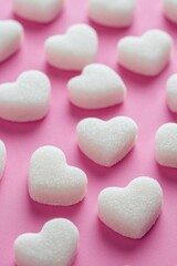 Obraz premium A cluster of white sugar hearts sit on a bright pink surface, perfect for a whimsical or romantic-themed project