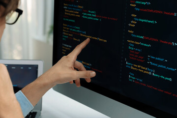 IT developer selecting by point on coding online software development information on pc comparing...
