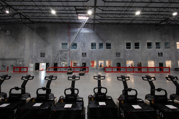 row of electric forklifts charging in warehouse Interior © Francisco