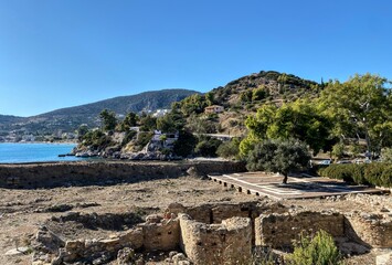 View of the Greek town of Tolo, its green mountain slopes  and the clearest waters from the hill where the ruins of ancient  Asina stand with the sity walls stil well   preserved