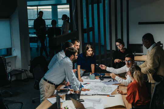 Business colleagues engage in brainstorming around a table. Multigenerational employees collaborate on a project, highlighting teamwork, innovative thinking, and creativity in a modern office. - Powered by Adobe