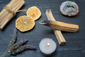 Ritual objects for spiritual practice, Palo Santo, candle and crystal on black stone background