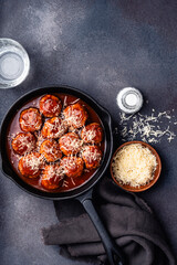 Beef meatballs with tomato sauce and parmesan cheese on gray background, copy space