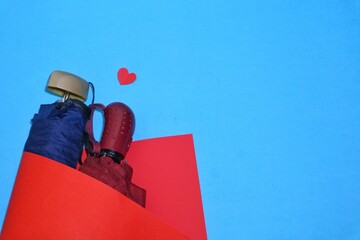 umbrella wrapped in red paper with blue background and heart symbol. top view. romantic and love concept