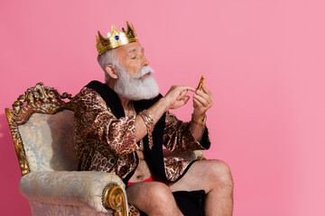 Photo of confident eccentric king character wear trendy leopard bathrobe hold push button phone isolated on pink color background