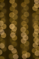 Golden yellow cozy blurred garland lights, Christmas and New Year bokeh background. Holiday Illumination concept. For greeting card, cover, wallpaper, backdrop