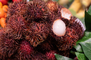 Rambutan fruits, with their hairy shells, arranged at a tropical market.