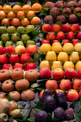 A selection of apples in various colors stacked at a market.