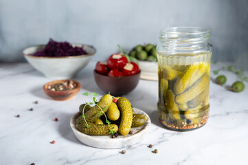 Pickled cucumbers and gherkins in a bowl and jar, rich in probiotics, fermented probiotic-rich foods.