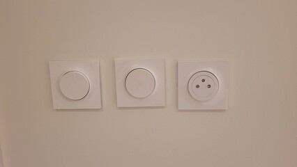 Implantation de 2 interrupteurs muraux avec une prise de courant  sur mur blanc