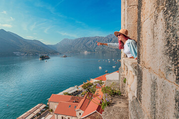 Woman pointing at the picturesque islands of Our lady of the rocks and Saint George from a high...