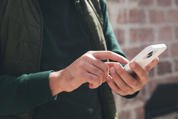 young man holding smartphone in hands