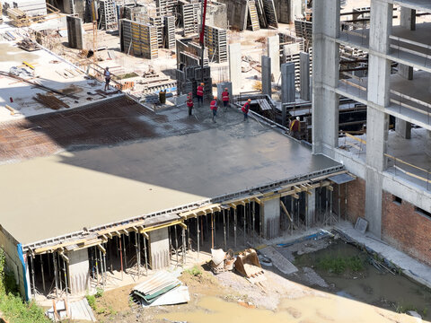 Aerial view of a construction site with heavy machinery for material lifting.