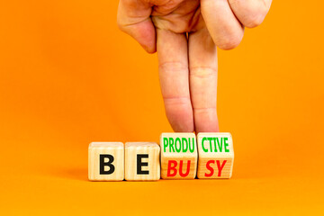 Be productive not busy symbol. Concept words Be productive Be busy on wooden block. Beautiful orange table orange background. Businessman hand. Business be productive not busy concept. Copy space.