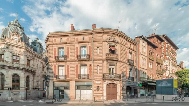 Panorama showing historic brick facades at Rue du Languedoc and Theodore Ozenne intersection timelapse in Toulouse, France. Shops, cafes, road traffic near Carmes metro station in vibrant city center