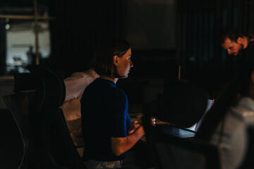 A dedicated business team collaborates late into the night to meet a critical project deadline, sharing ideas and strategies within a diverse, multicultural environment.