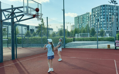 Children and sports. Teenage girl playing basketball on the playground.