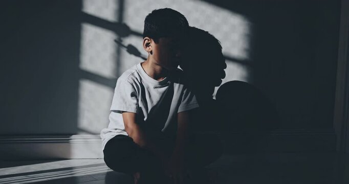 Sad Boy Sitting Alone in Shadowed Room by Window with Dramatic Light and Reflections, Highlighting Solitude and Emotion