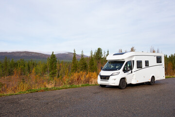 White camper van parked in a serene pine forest, offering a tranquil escape into nature near Finland border