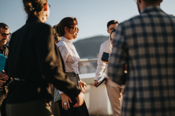 A group of multiracial business colleagues celebrating an achievement on a rooftop. The setting sun creates a warm, motivational atmosphere, highlighting teamwork, diversity, and success in the modern
