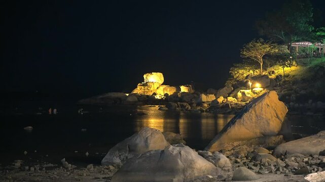 A famous landmark of Nha Trang city is the natural stone landscape of Hon Chong at night in artificial lights. A recent low tide allowed a group of people to wander around Hon Chong in search of crabs