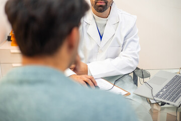 Obraz premium Dentist explaining diagnosis to patient showing medical records on laptop