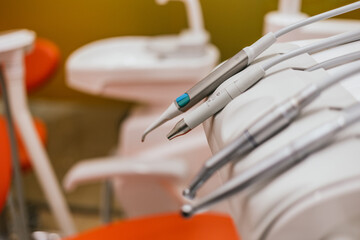 Modern dental tools resting on chair in dentist office