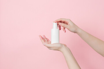 Hand holds white cream bottle with pump. Concept of beauty. Daily beauty product