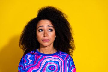 Photo of pretty young girl look disappointed upset empty space wear trendy colorful blue outfit isolated on yellow color background