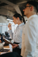 Multicultural business workers discussing and analyzing a project together in an office. A diverse team enjoys coffee during the meeting, creating a collaborative atmosphere.