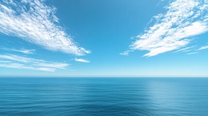 Obraz premium Serene ocean panorama with blue skies and wispy clouds