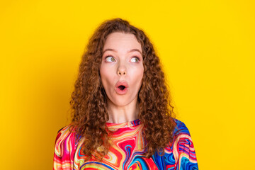 Colorful style meets vibrant expression in this photo of a young woman with red curly hair against a yellow background