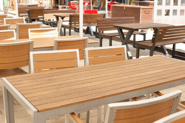 A wooden table with wooden chairs in cafe.
