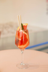 Cold grapefruit cocktail with slices of fresh grapefruit decorated twig rosemary. Sunny day shadows. A refreshing summer mocktail