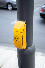 Button on a traffic light to allow pedestrians to cross the road. Yellow box with a button on a...